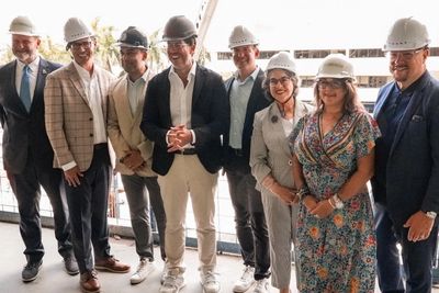 Grupo de personas con cascos en obra en construcción.