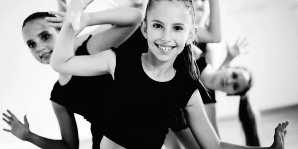 Three girls dancing and smiling at the camera.