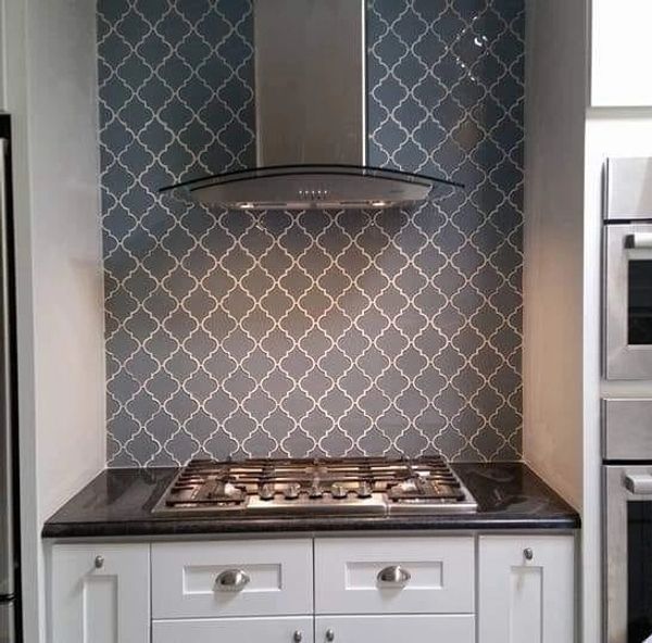 Kitchen Renovation in Bismarck with glass lantern tile, black granite countertops, and hood