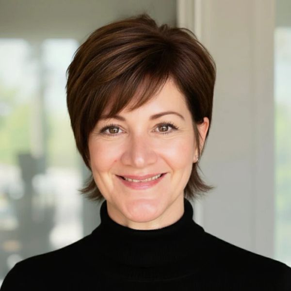 Smiling woman with short brown hair and black turtleneck.