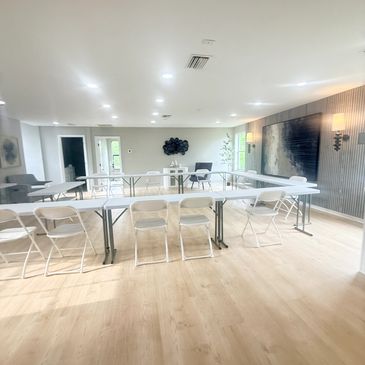 Bright conference room with white tables and chairs.