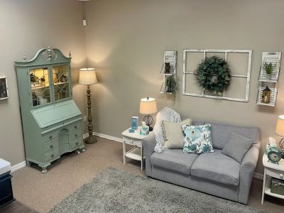 Cozy living room with grey sofa and decorative green cabinet.