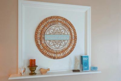 Decorative shelf with a wooden wreath and various small items.