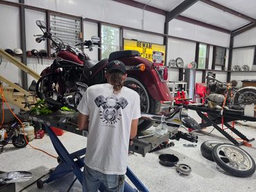 Man working on a motorcycle in a garage.