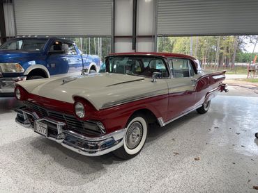 A classic red and white vintage car in a garage.