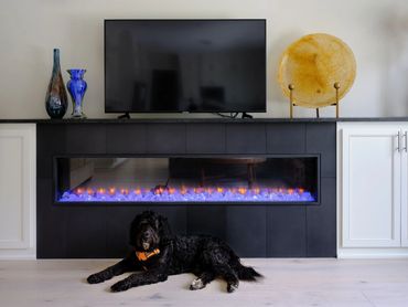 Modern linear electric fireplace with built in cabinets and granite countertop
