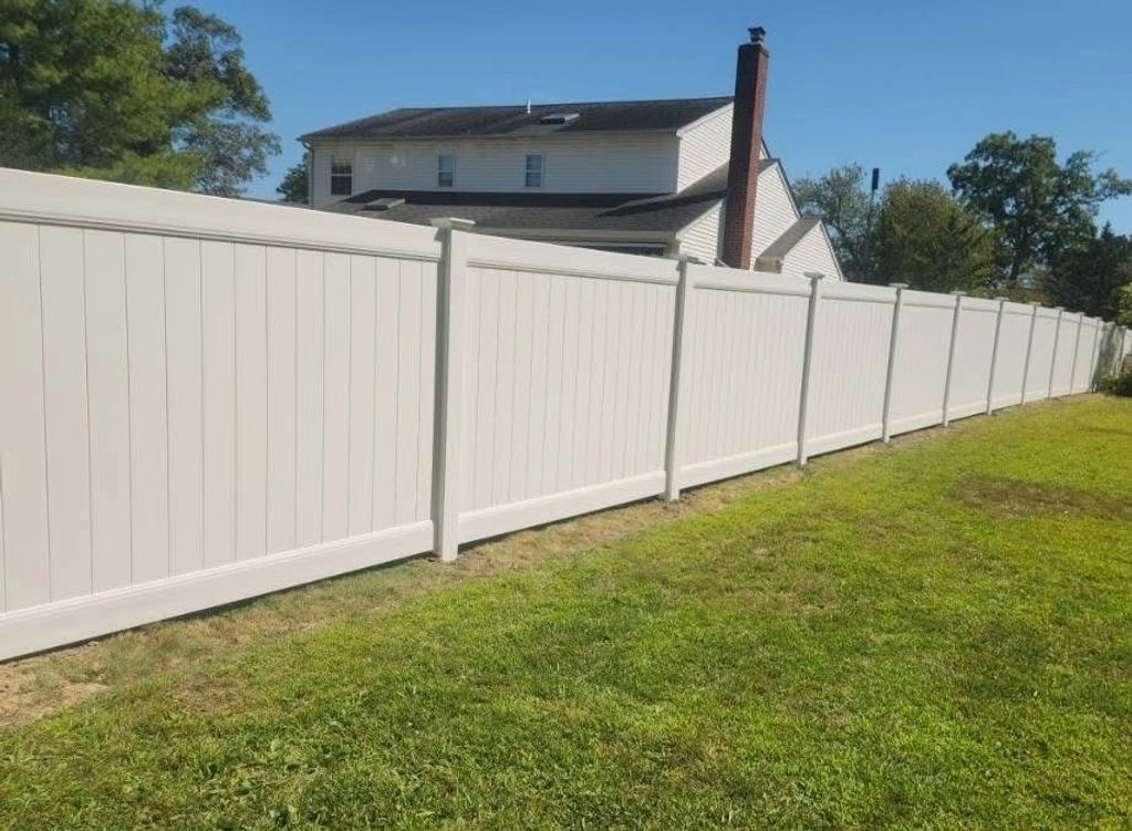 Classic white PVC fence on property line between neighbors.