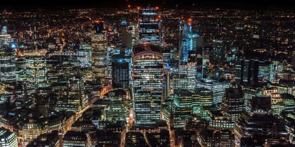 Night view of a brightly lit city skyline with numerous skyscrapers.