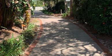 Garden pathway paving with brick edging creating durable walkway through landscaped garden