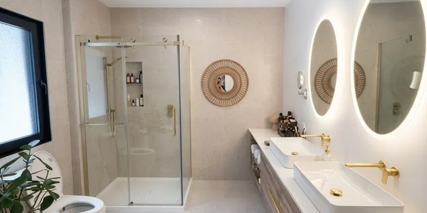 Salle de bain moderne avec douche en verre et miroir rond éclairé.