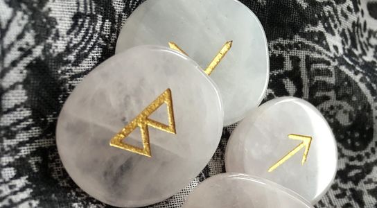 Viking Nordic runes engraved in gold scattered on a grey and white scarf