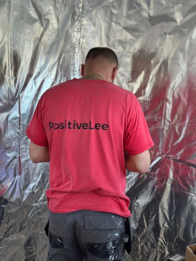 Person wearing a red shirt with 'PositiveLee' on the back.