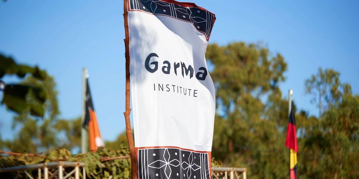 Flag of the Garma Institute waving outdoors.
