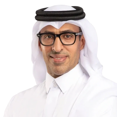 Confident man wearing traditional Middle Eastern attire and glasses, smiling with arms crossed.