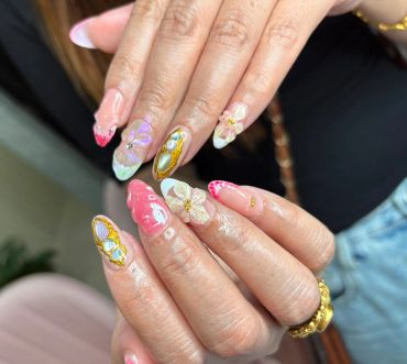 Colorful 3D floral nail art on long nails.