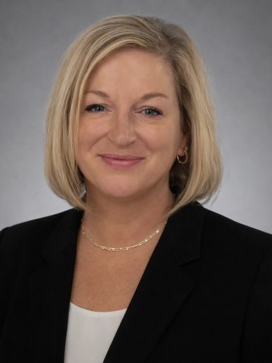 Professional woman smiling in business attire.