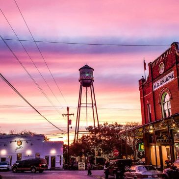 Sunset sky with water tower and historic building in a small town.