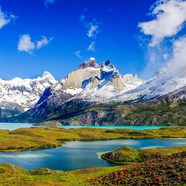 Snow-capped Torres del Paine mountains with turquoise lakes and green valleys in Patagonia.