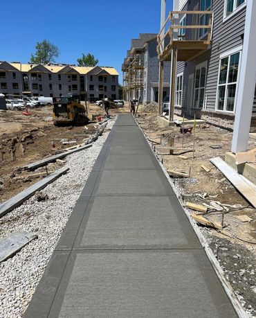 Newly poured concrete sidewalk at an apartment construction site.