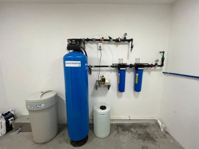 Sistema de filtración de agua instalado en una pared blanca.