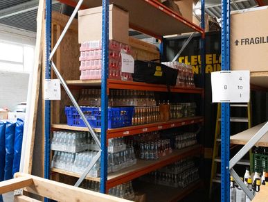 shelving storing drinks and equipment in a warehouse
