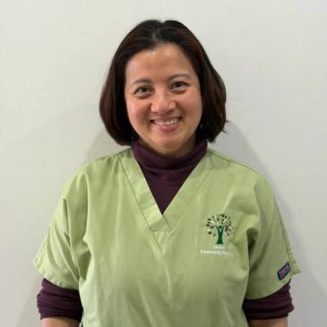 Smiling woman in green medical scrubs.