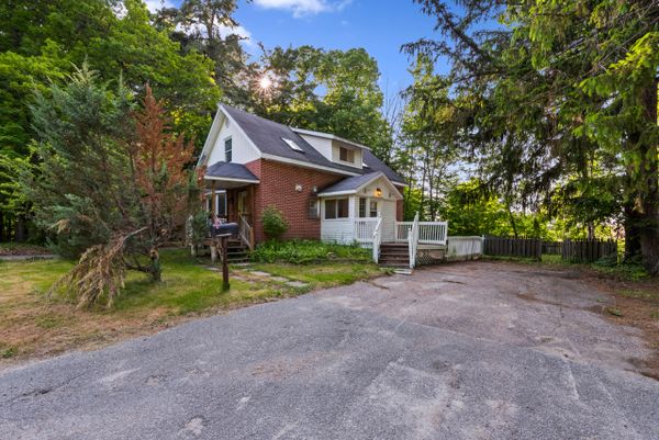 Brick house with blue sky surrounded by trees