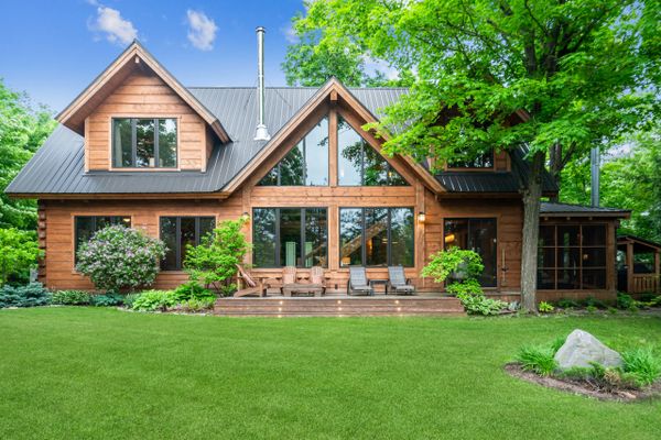 Large house with windows, blue sky and green grass