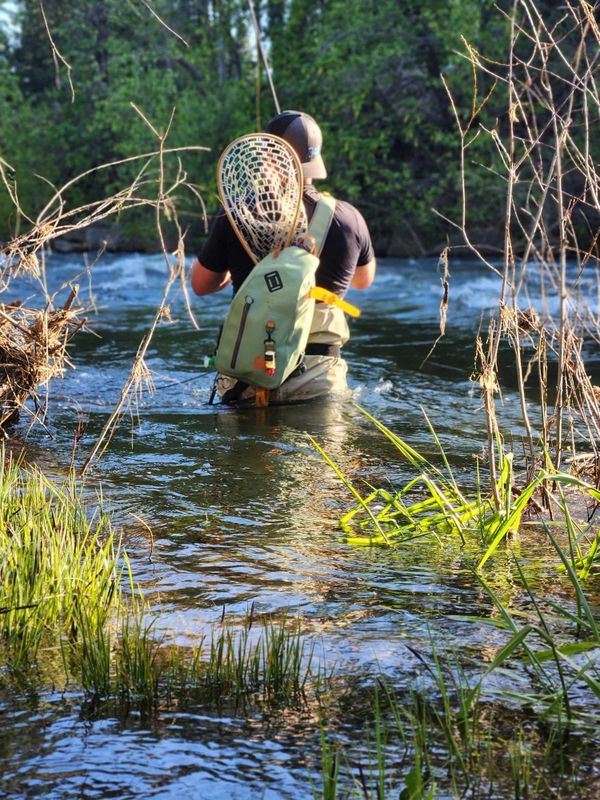 Person fly fishing on Upper Sacramento River wearing fishing gear