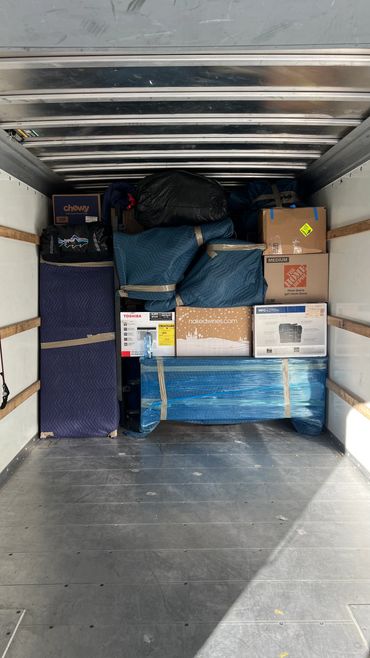 Neatly packed moving boxes and furniture inside a truck.