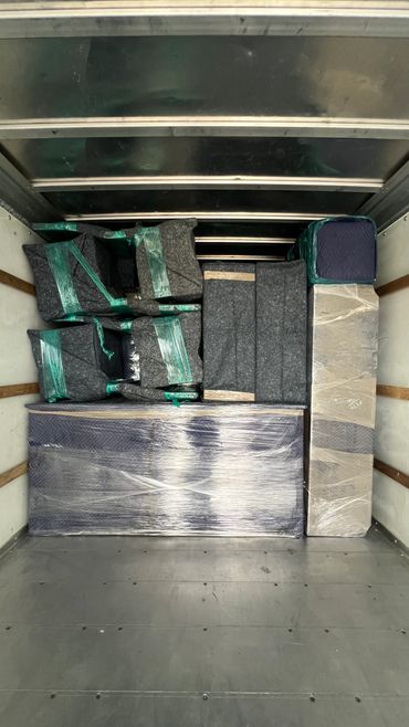 Neatly packed and wrapped furniture inside a moving truck.
