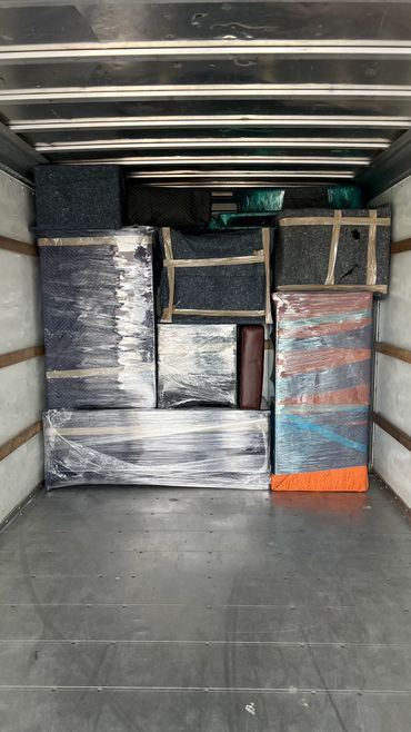Neatly packed and wrapped furniture inside a moving truck.