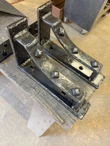 Custom Steel blacksmith mantel brackets with diamond hammered emblems