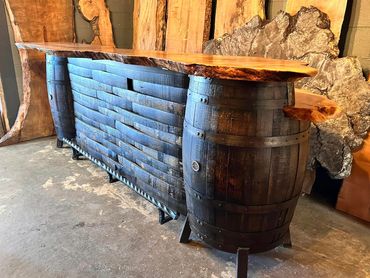 Whiskey barrel stand-alone bar with barrel stave panels, live edge tops, and twisted steel footrest