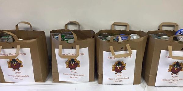 Brown paper bags with canned goods and Thanksgiving labels from Eastern Virginia Adult Care.