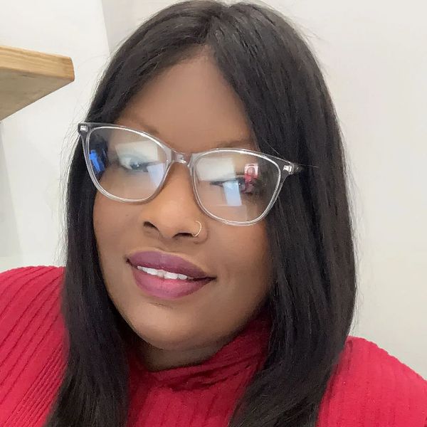 Smiling woman wearing glasses and a red sweater.