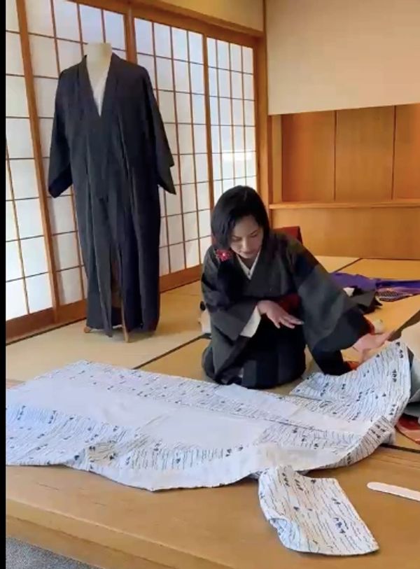 Evelyn wearing kimono demonstrating how to fold a yukata.