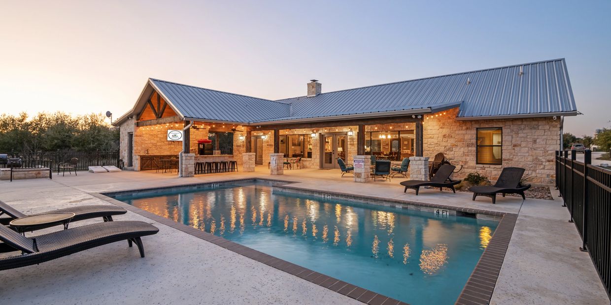 Modern house with outdoor pool and patio seating at dusk.