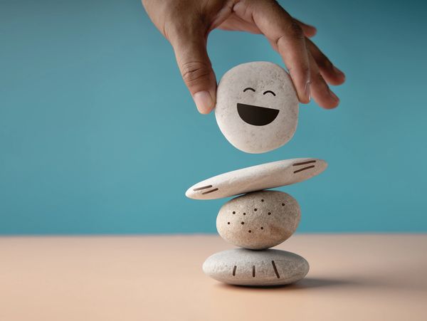 Placing a stone with a happy face on a figurine
