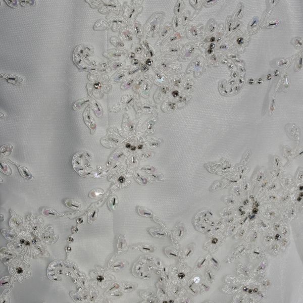 Hand beading detail on a lace motif sewn to a wedding dress
