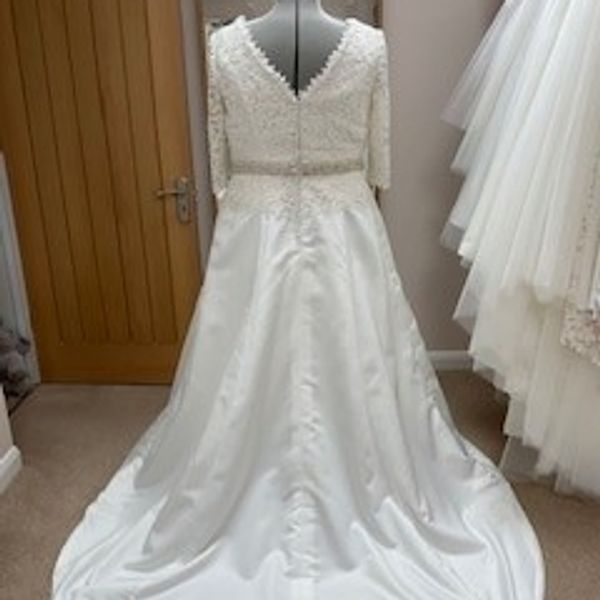 Back view of wedding dress on a tailors dummy Guipure lace v neck top and an a-line satin skirt