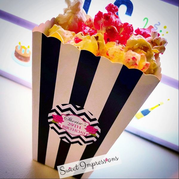 Cinnamon red popcorn in black and white striped popcorn box
