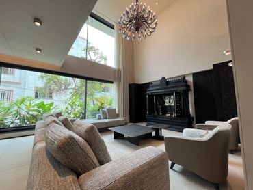 Modern living room with large windows and elegant chandelier.