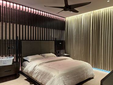 Modern bedroom with a large bed and soft lighting.