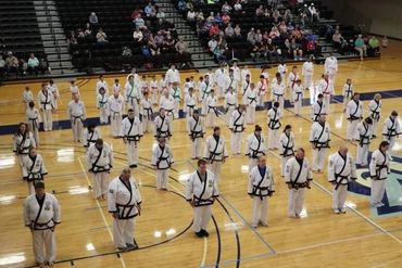 Organized gathering of karate / Tang Soo Do / martial arts students, mostly black belts, at event