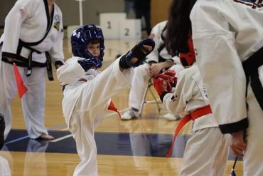 Two young karate / martial arts / Tang Soo Do students sparring at event