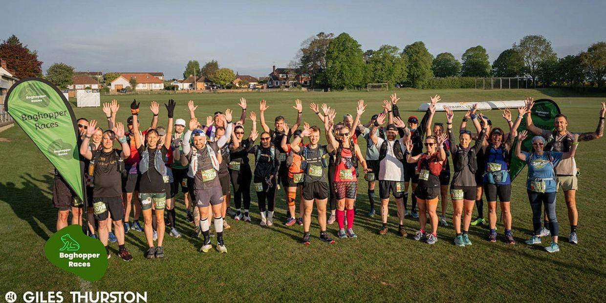 Group of runners waving at the start of a Boghopper Races event.
