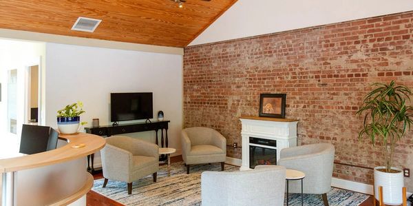 Cozy modern waiting area with brick wall and armchairs.