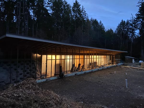 The Earthship, no windows yet, but you can see the light from inside shining through the greenhouse.