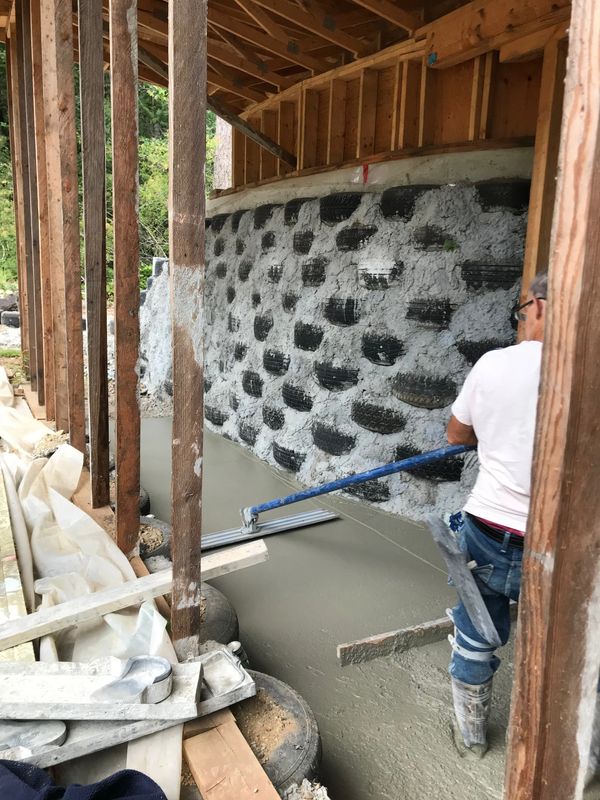 Levelling the newly poured cement in the greenhouse.